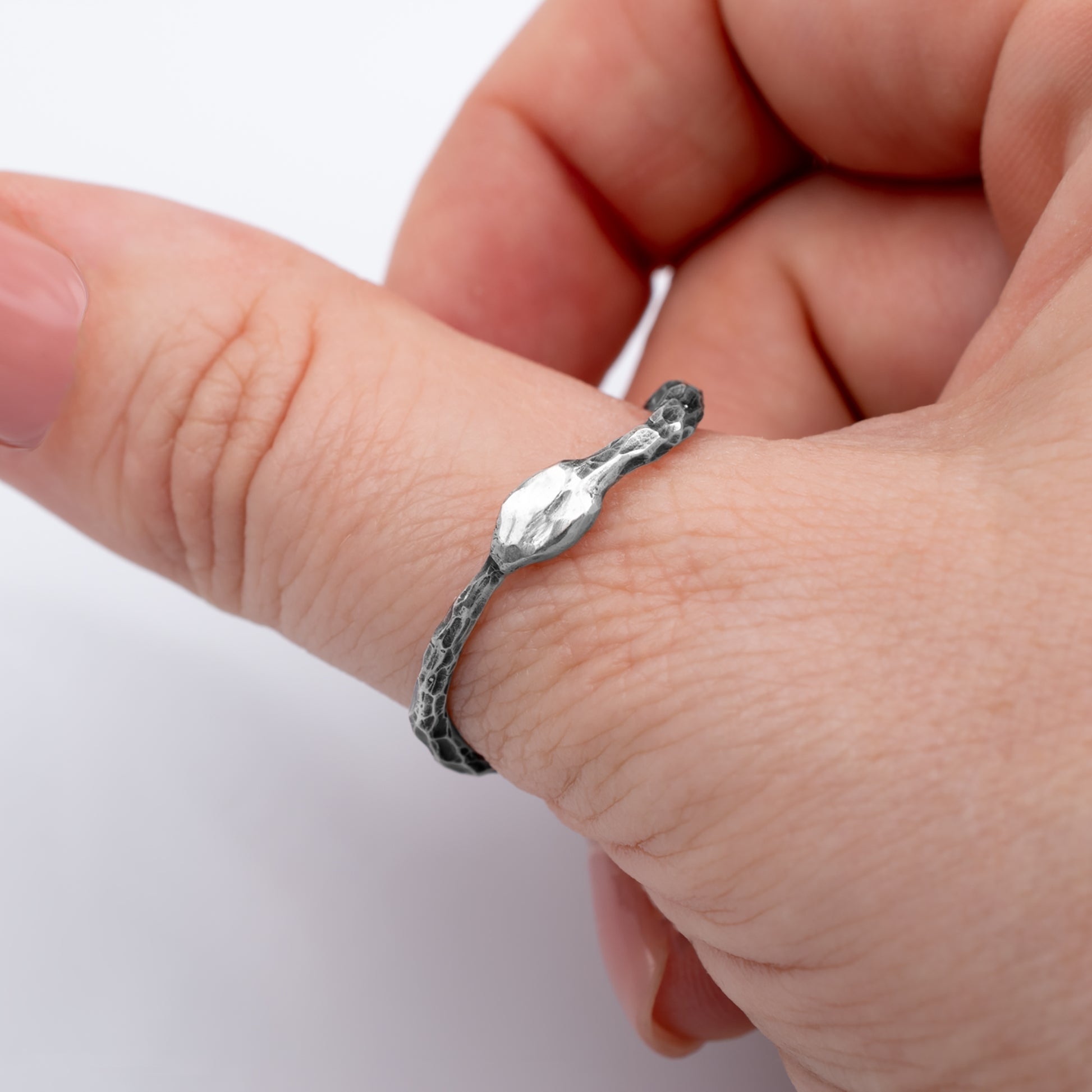 Silver ring on a person's finger against a white background