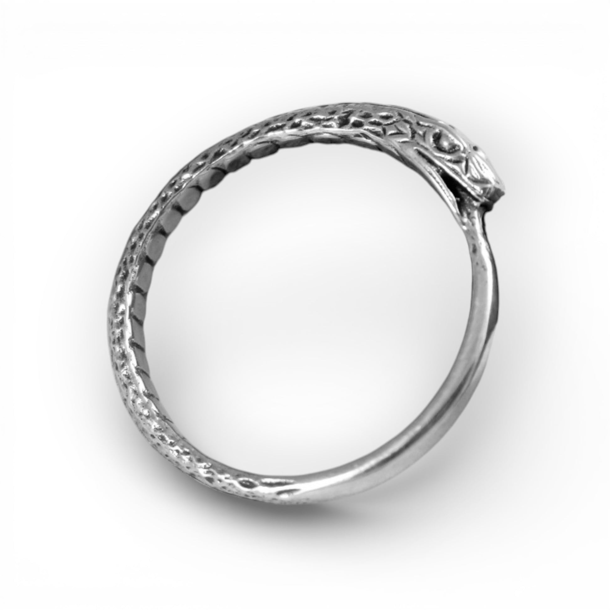 Silver ring with intricate design on a white background