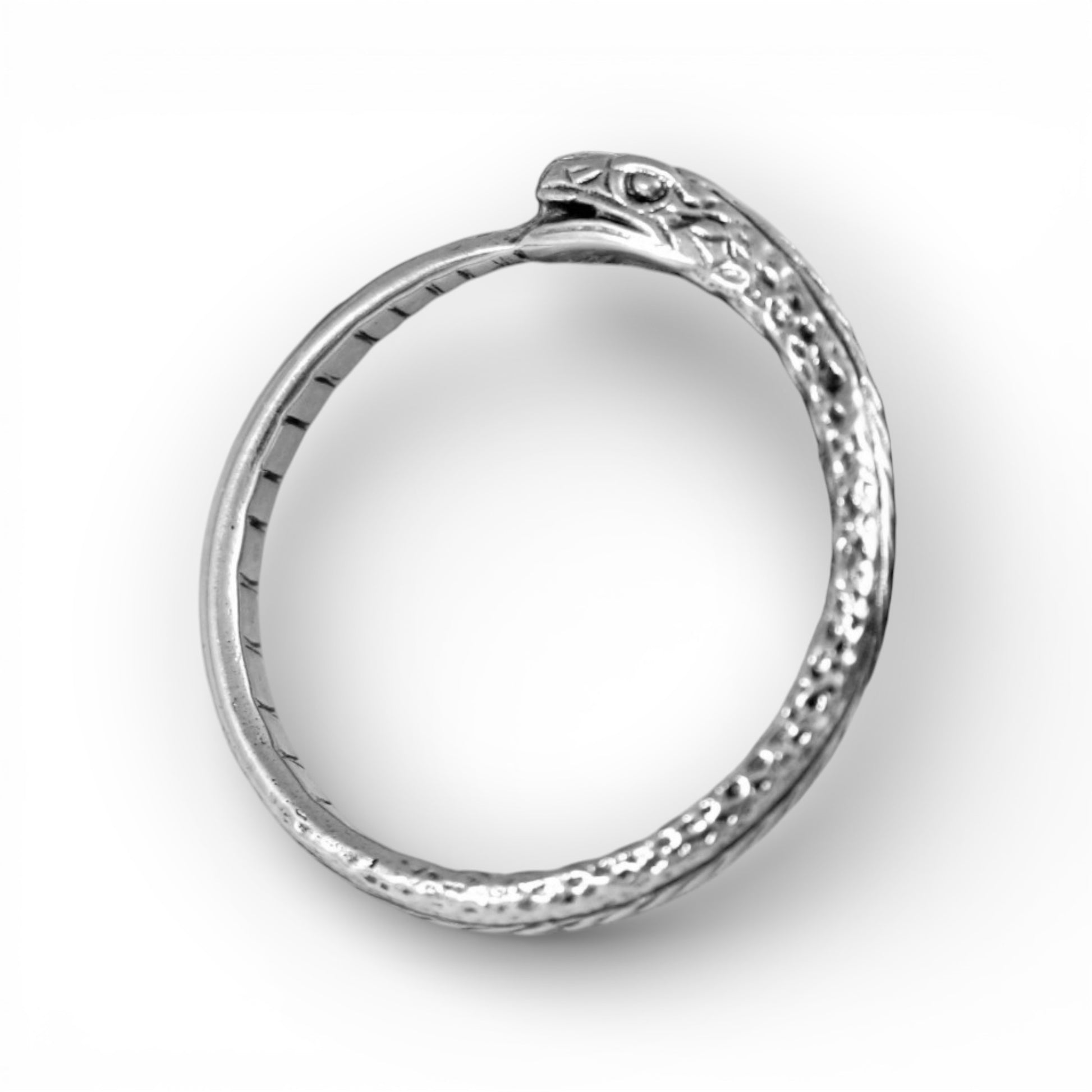 Silver ring with textured design on a white background
