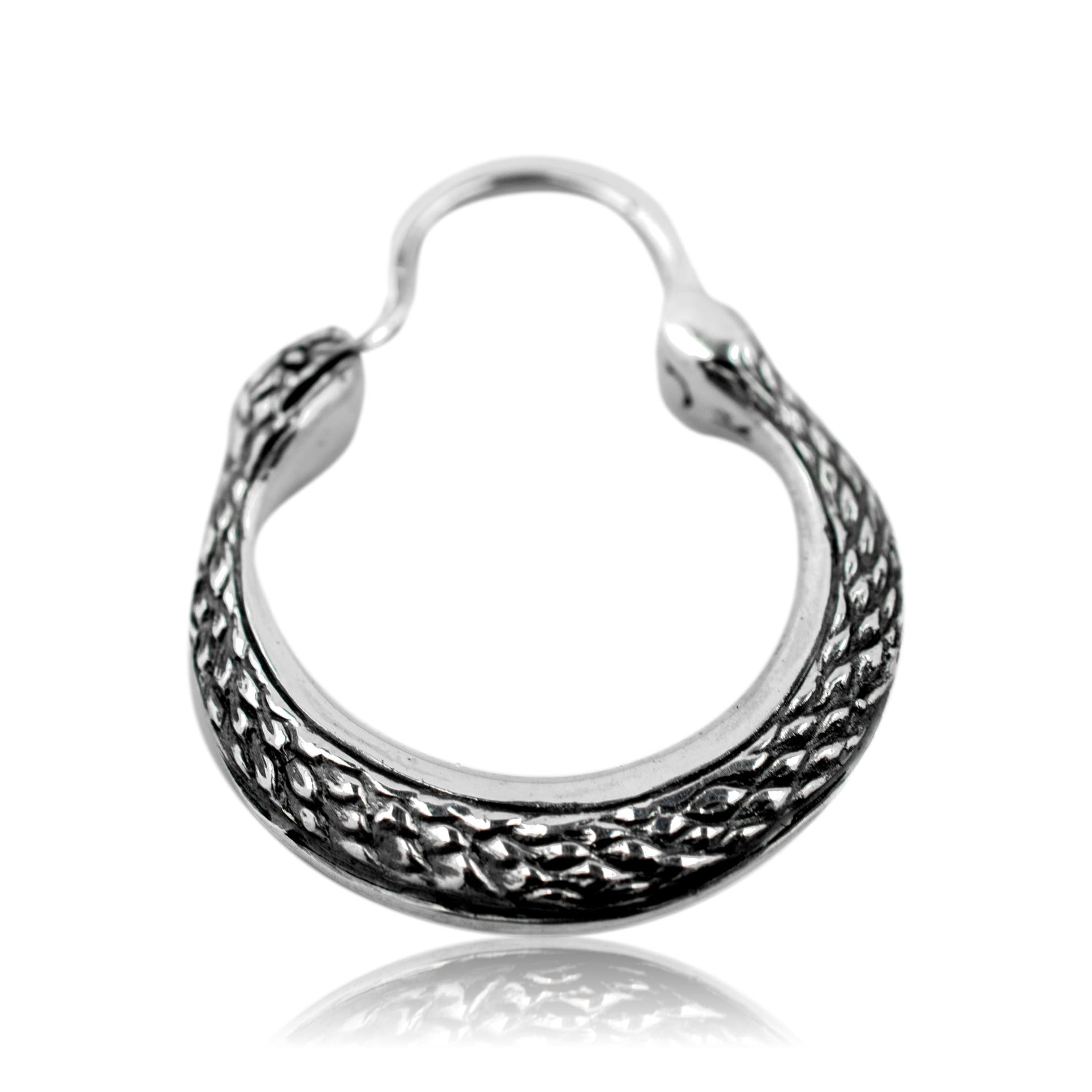 Silver hoop earring with intricate design on a white background